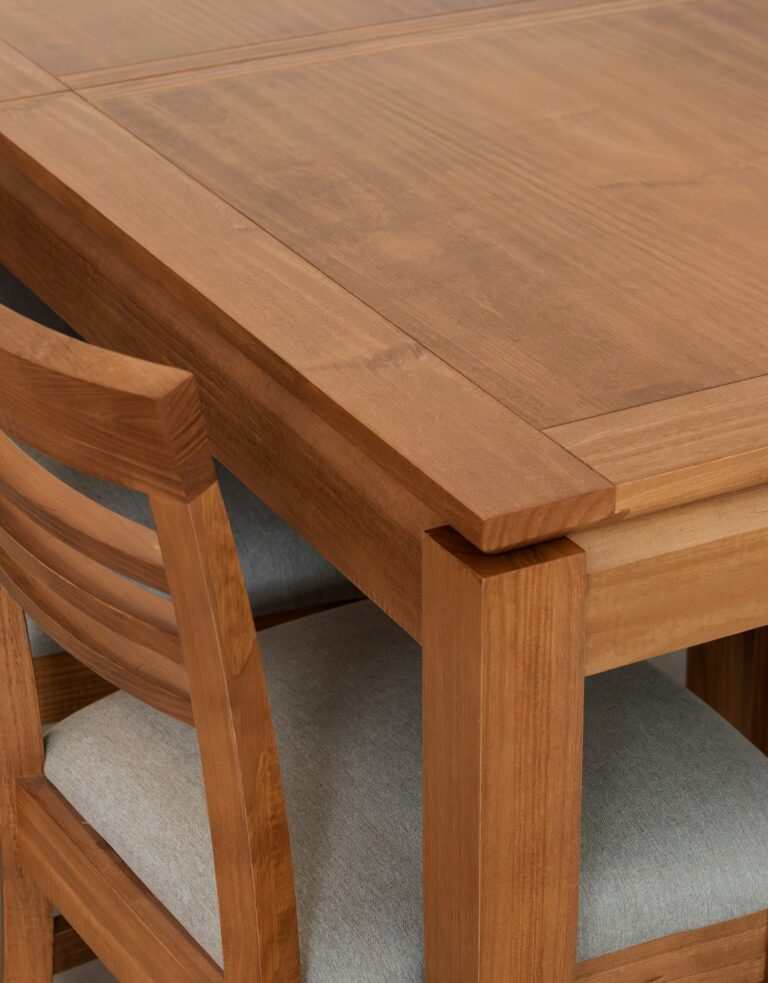Corner of a solid wood dining table with joined tabletop and legs, inspiration for custom tables