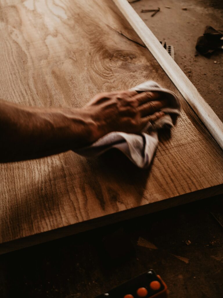 Oil being rubbed into a solid wood tabletop, inspiration for custom tables