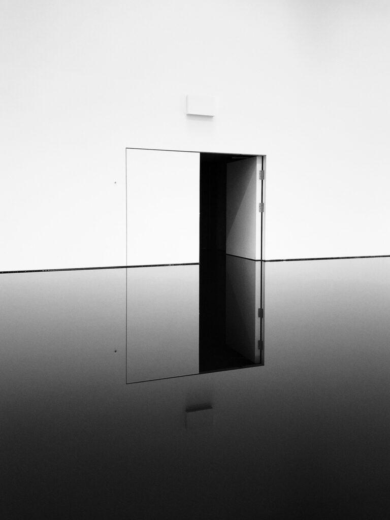 Minimalist white door in an all white wall, inspiration for custom doors