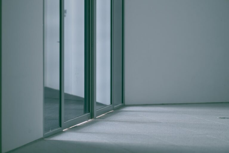 Glass sliding door in a bright empty room, inspiration for custom doors