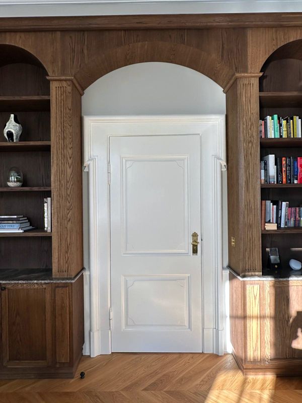 Arched doorway between smoked oak bookcases