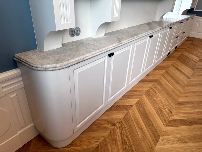 White kitchen with rounded corner and natural stone worktop