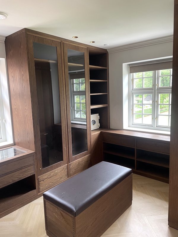 Walk-in wardrobe with glass doors and drawers in smoked oak