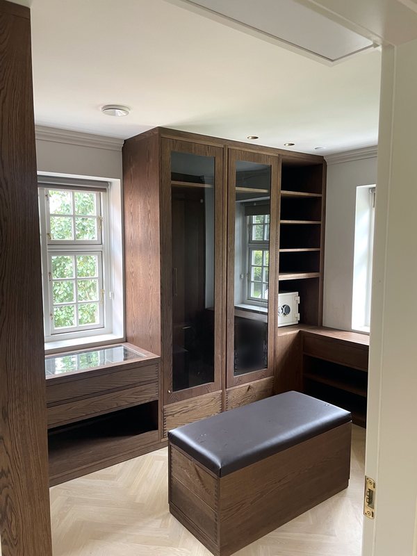 Walk-in wardrobe fitted in smoked oak with herringbone floor